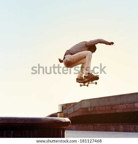 Skateboarder performs a trick in the city on a sunny day