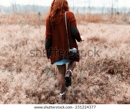 Fashion beautiful girl hipster goes to share with a camera on his shoulder