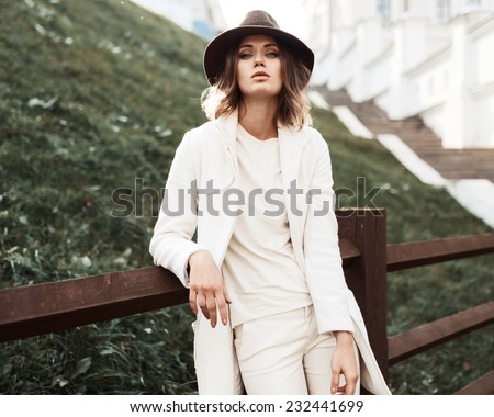 Beautiful fashionable woman in a hat and coat posing