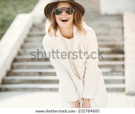 Beautiful girl close up with a hat laughing on a sunny day