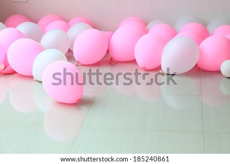 pink and white balloon on floor with white wall background