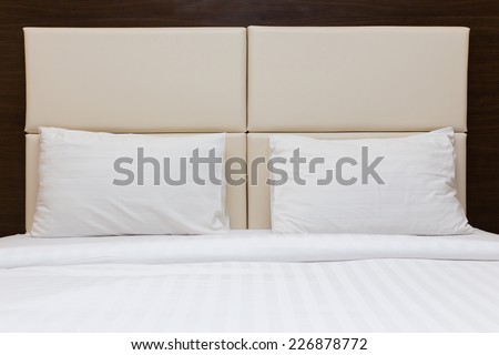 white pillow and leather headboard in bedroom