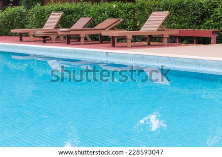 blue swimming pool in green garden of the resort
