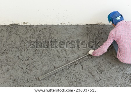 plasterer concrete cement worker plastering flooring of house construction