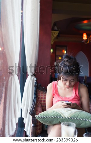 women lifestyle using a mobile phone in cafe coffee shop with texting message on app smartphone playing social network