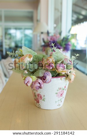 flowers vase decoupage decorated on wooden table at living room, artificial flowers in vase
