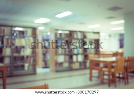 bookshelf and table desk in library, education abstract blur defocused background