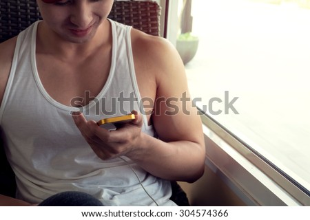 young man using a mobile phone with texting message on app smartphone, playing social network and shopping online