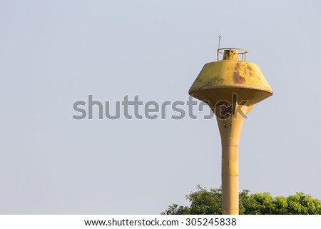 old yellow water tank tower on empty sky