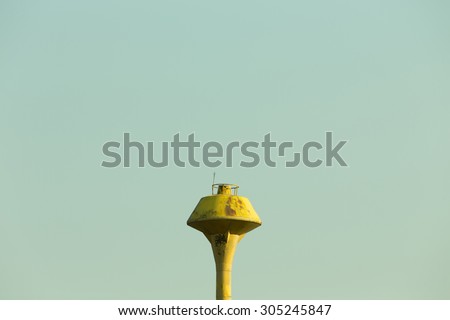 old yellow water tank tower on empty sky