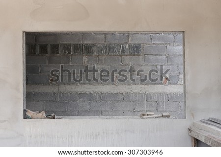 window on cement wall with brick wall background in construction building