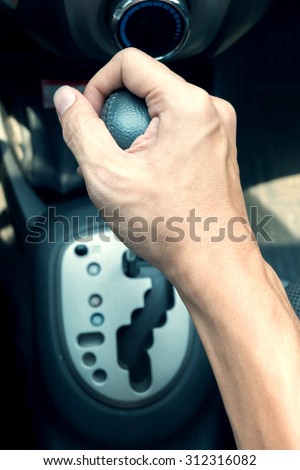 driver man hand holding automatic transmission in car