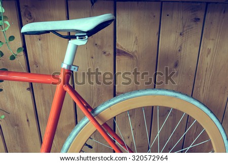 fixed gear bicycle parked with wood wall, close up image part of bicycle