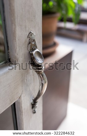 open the door, close-up door handle style ancient on vintage white wooden door