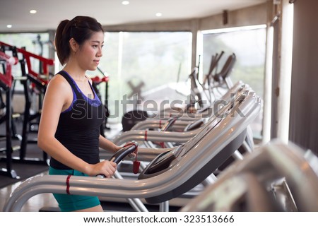 sport woman young person running on treadmill cardio equipment in fitness gym center