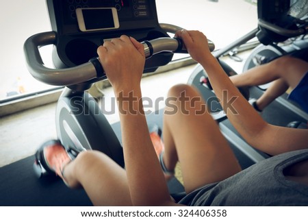 woman exercise riding bicycle in fitness center, activity of healthy care