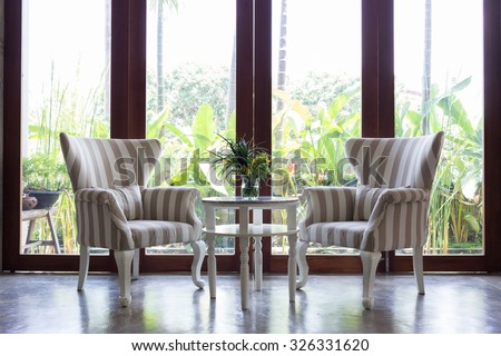 design of interior living room with sofa furniture with mirror window and green garden background