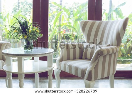 design of interior living room with sofa furniture with mirror window and green garden background