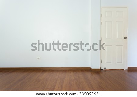 empty room with brown wood laminate floor and white mortar wall background