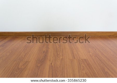 empty room with brown wood laminate floor and white mortar wall background