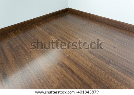empty room interior, brown wood laminate floor and white mortar wall