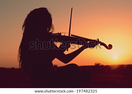 Girl playing the violin at suns
