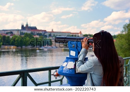 The girln looks through telescope in Prague