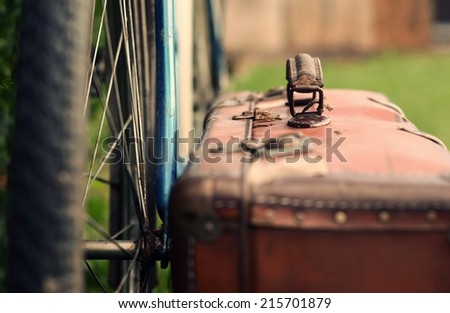 Old bicycle and old brown suitcase with a retro effect