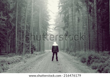 Man stands in the fog in the forest