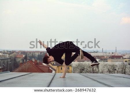 Young guy dancing break dance on the roof