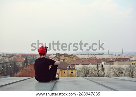 Young guy siting on the roof