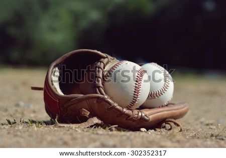 Baseball ball in leather glove lying on the playground