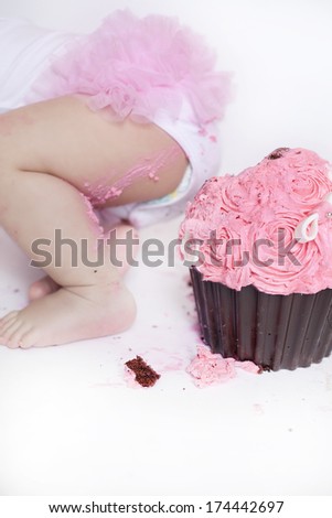 Baby girl and her birthday cake doing a smash cake in a studio