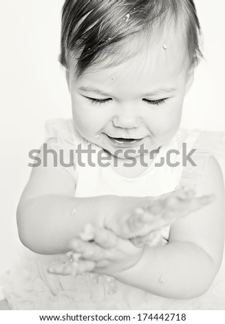 Baby girl and her birthday cake doing a smash cake in a studio