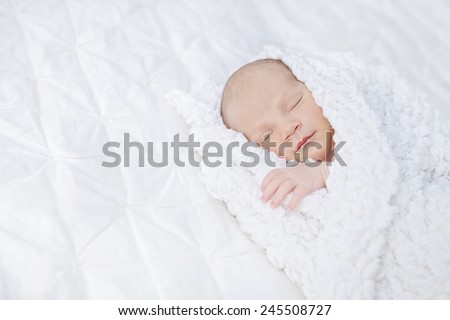 Baby sleeping in a white blanket
