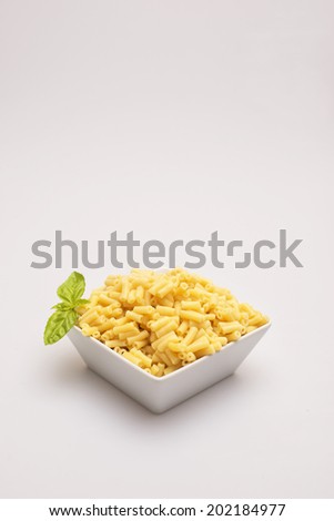 Cooked macaroni in bowl on white background.
