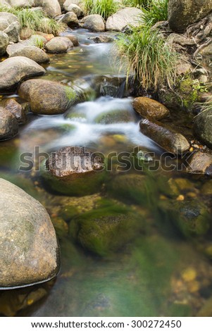 Rocks and flowing water in a creek bed at the base of the mountain Spicers Gap, Queensland, Australia.
