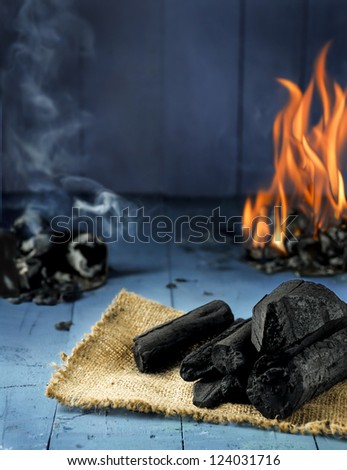 Charcoal,fire and smoke on blue wood