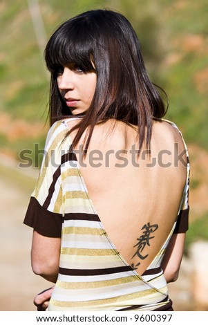 stock photo : Beauty portrait with oriental tattoo printed in her back