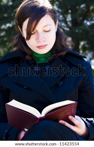 Young woman enjoying a book in the park