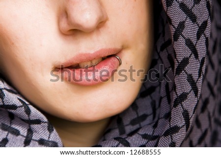 Sensual pierced mouth covered by violet veil