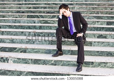 Worried businessman in marble stairs background.