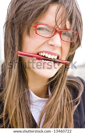 stock-photo-young-businesswoman-in-red-glasses-bitin-a-pen-13460722.jpg