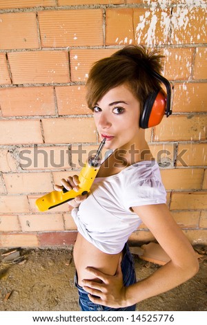 Female laborer with screwgun and ear protector