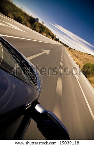 Cruising the countryside in a blue car at high speed.