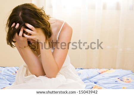 Tormented young woman in her bedroom