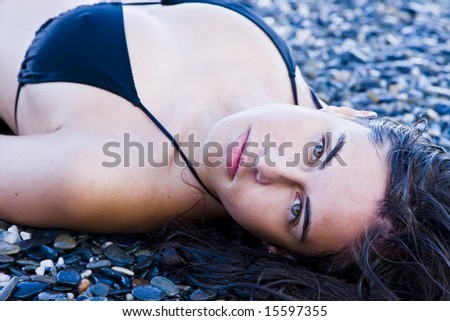 Laying beauty wearing black small bikini.