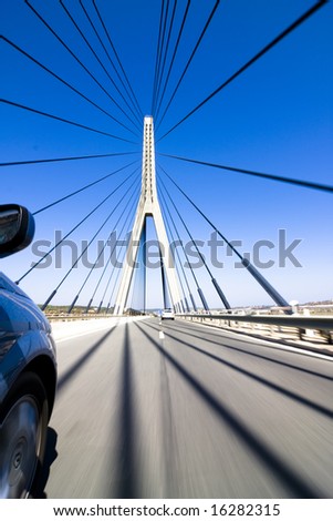 Wide angle driving over a bridge at high speed. Focus on bridge tower.