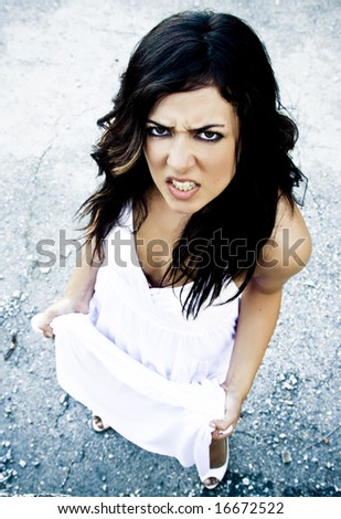 Angry young woman in elegant white dress