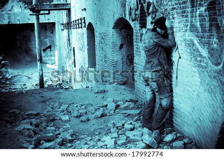 Tormented young woman crying over brickwall